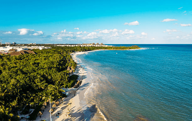 Aerial view of a white-sand beach between jungle and turquoise sea